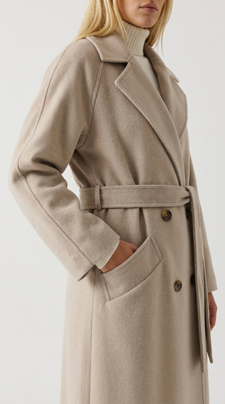 Close-up of the brushed alpaca wool blend fabric, notch lapel and tie belt on the apricot white Forest Hill coat
