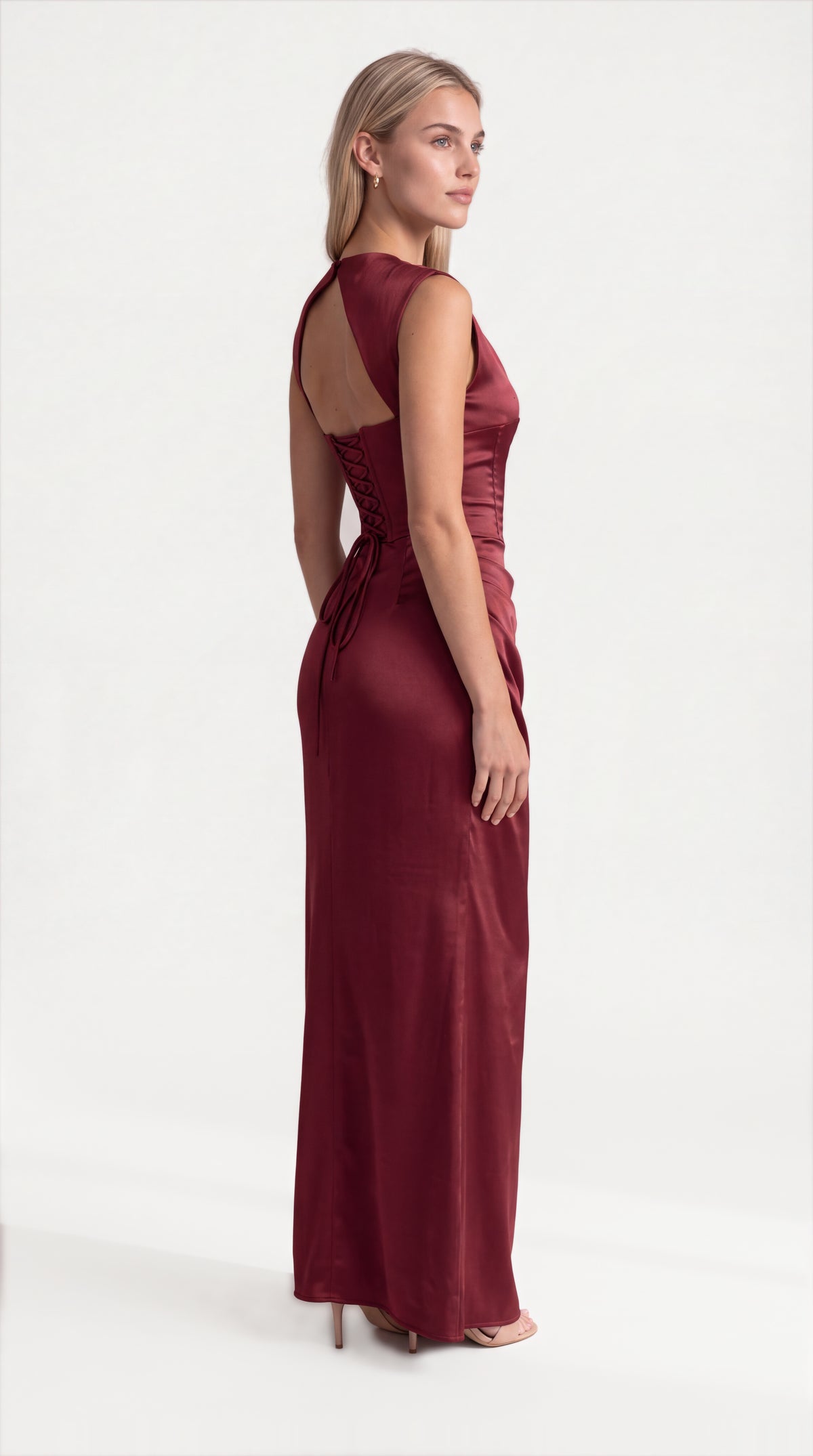 Burgundy satin corset maxi dress with draped neckline for women, side view of the Genevieve Satin Corset Maxi Dress – Burgundy showing the relaxed fit and length, ELLA Toronto