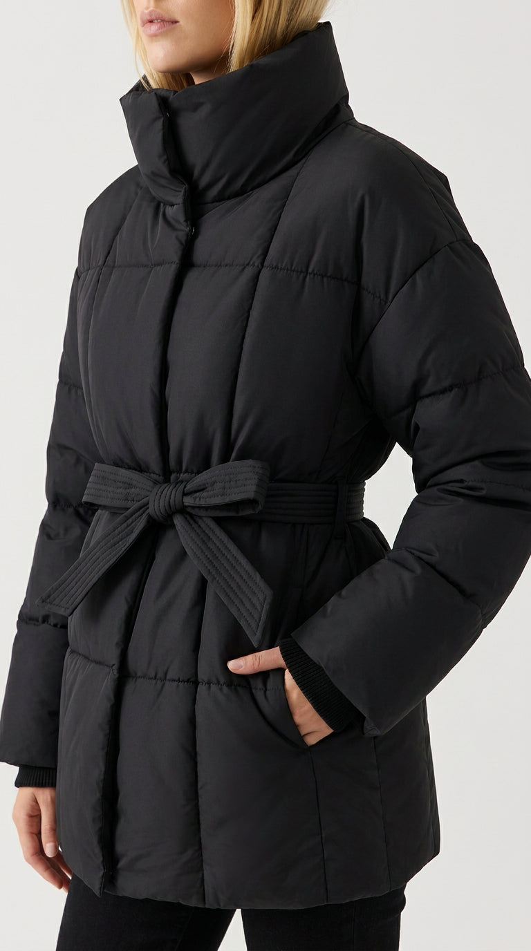Close-up of the black belted puffer jacket with tie belt bow, stand collar and quilted panels, ELLA Toronto